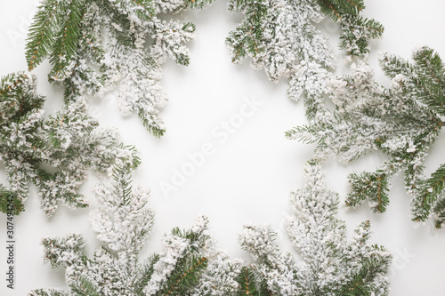 Christmas still life. Spruce branches form a frame with white copespace in the middle photo