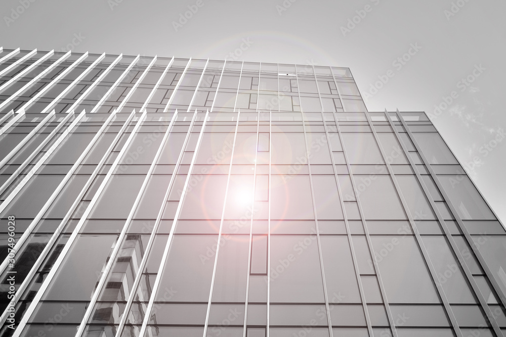 Modern office building wall made of steel and glass with blue sky. Glass surface with sunlight. Black and white. Modern office building wall made of steel and glass with blue sky. Glass surface with sunlight. Black and white.