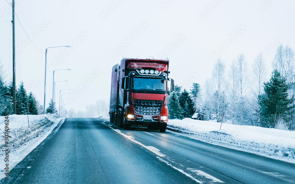 Winter road with snow. Truck in Finland. Lorry car and cold landscape of Lapland. Europe forest. Finnish City highway ride. Roadway and route snowy street trip. Delivery in downhill driveway driving Winter road with snow. Truck in Finland. Lorry car and cold landscape of Lapland. Europe forest. Finnish City highway ride. Roadway and route snowy street trip. Delivery in downhill driveway driving