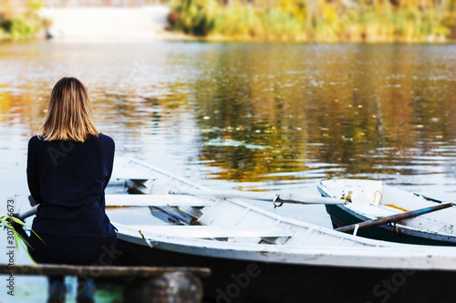 Lonely slender girl near the boat