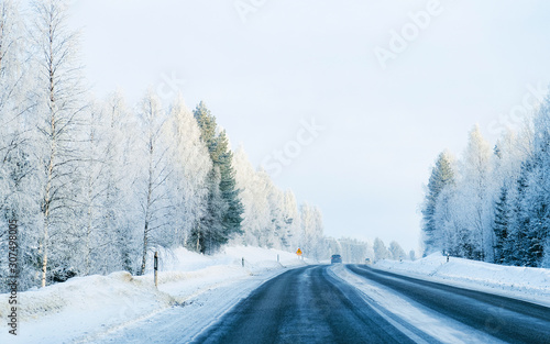 Car on Winter road with snow in Finland. Auto and Cold landscape of Lapland. Automobile on Europe forest. Finnish City highway ride. Roadway and route snowy street trip. Driving