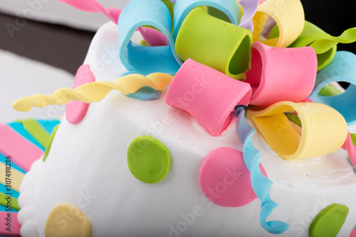 Colorfully Decorated White Birthday Cake Closeup with Fondant Icing Swirls