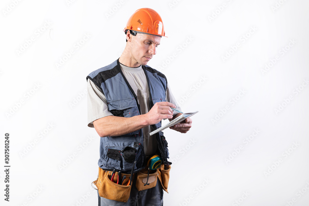 Builder with a notepad. In a helmet and a robe. Writes data. Builder with a notepad. In a helmet and a robe. Writes data.