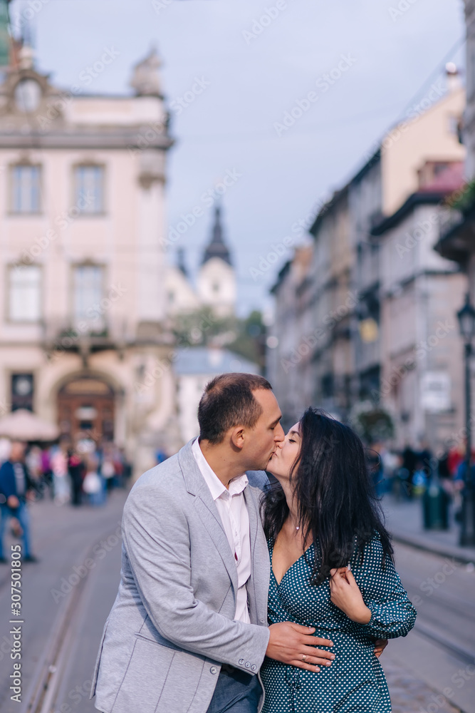 guy and girl closed eyes and kissing on city street. close up.