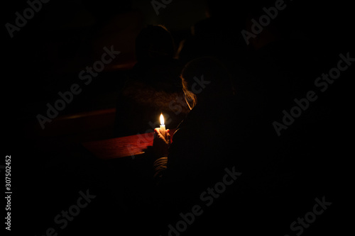 A woman holding a candle at darkness © Miroslaw