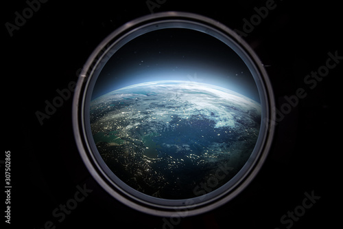 Porthole of space station. Earth on the background. Elements of this image furnished by NASA 