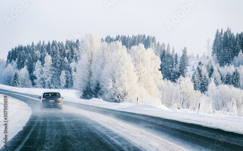 Car on Winter road with snow in Finland. Auto and Cold landscape of Lapland. Automobile on Europe forest. Finnish City highway ride. Roadway and route snowy street trip. Driving