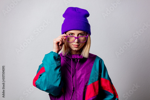 Blonde girl in 90s style jacket and hat with glasses