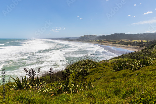 Scenic view of Muriwai Beach against blue sky during sunny day, Auckland, New Zealand photo