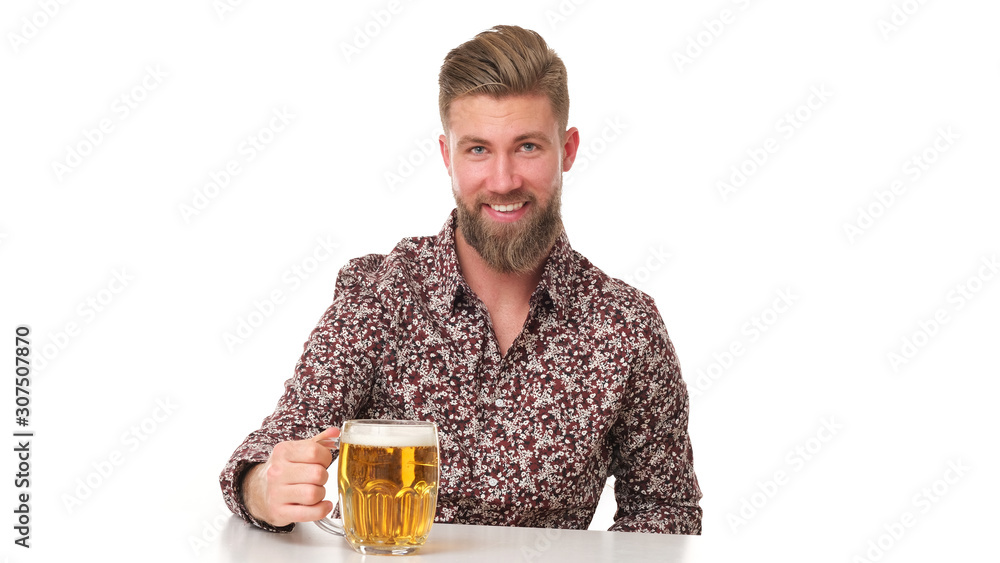 Young man with beard in flowery pattern is drinking a beer. Young man with beard in flowery pattern is drinking a beer.