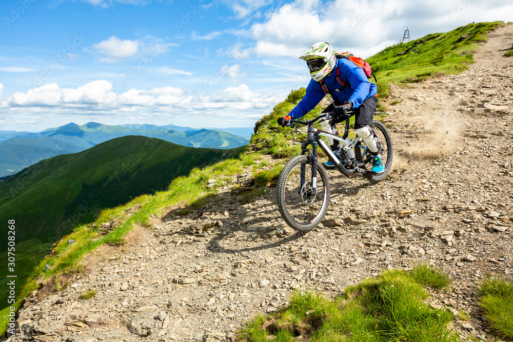 Enduro Cyclist is riding down the hill.
