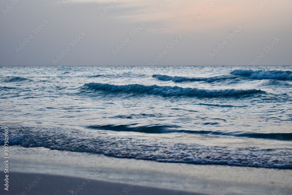 waves in the ocean and colourful sky just before sunset