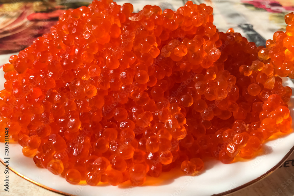 Red caviar on plate on the table. Salmon caviar. Dietary nutriti Red caviar on plate on the table. Salmon caviar. Dietary nutriti