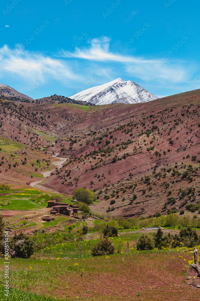 View of adobe village in the high snow-capped mountains in the Aït Bouguemez valley in Morocco