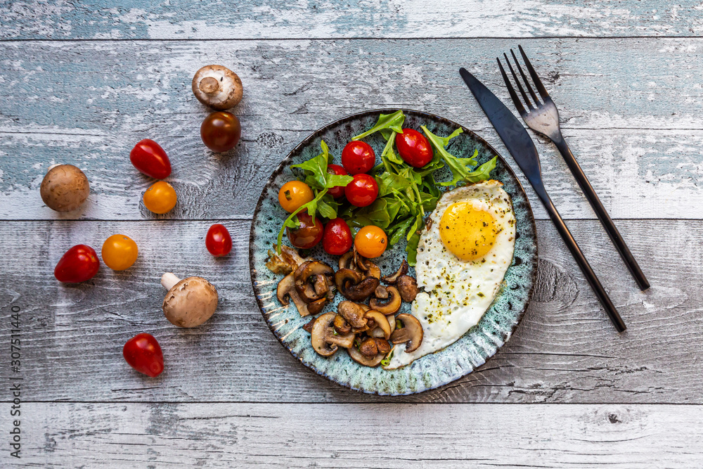 Low carb breakfast with fried egg, mushrooms, rocket and tomatoes Low carb breakfast with fried egg, mushrooms, rocket and tomatoes