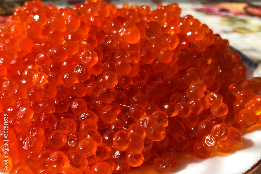 Red caviar on plate on the table. Salmon caviar. Dietary nutriti Red caviar on plate on the table. Salmon caviar. Dietary nutriti