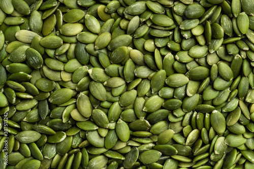 Peeled pumpkin seeds texture. Top view, flat lay