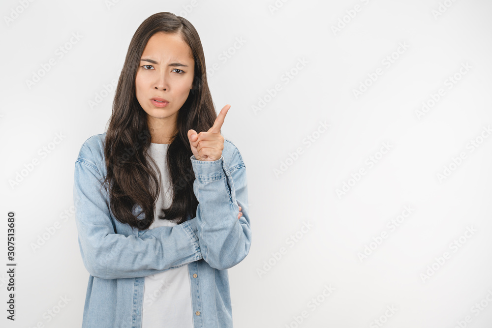 Serious young woman isolated on white studio background look at camera make warning sign Serious young woman isolated on white studio background look at camera make warning sign