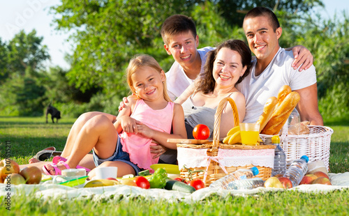 Parents with two teenagers enjoying  delicious meal on the picnic