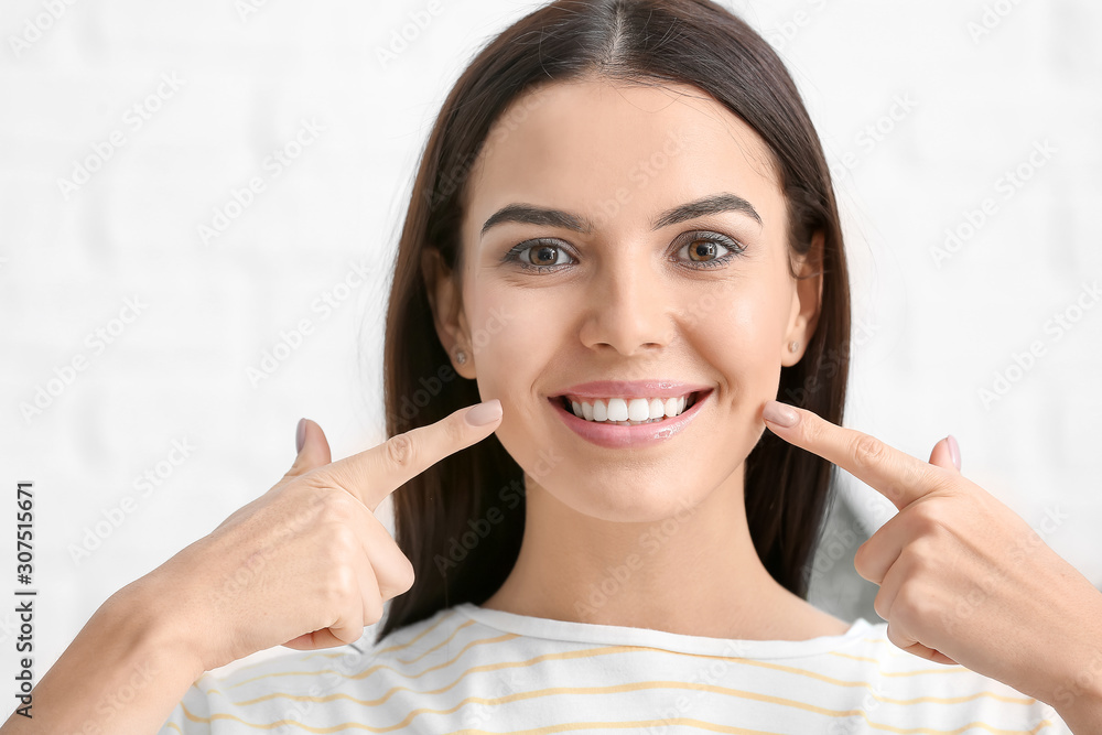 Beautiful young woman with healthy teeth on light background Beautiful young woman with healthy teeth on light background