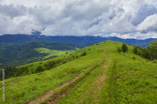 composite landscape. fence near the cross road on hillside meadow in mountains.