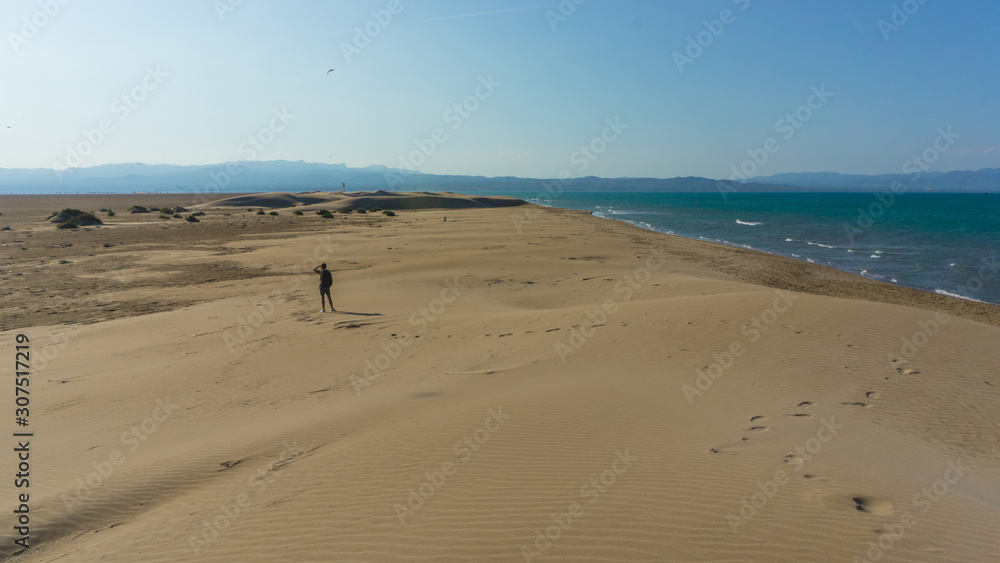 Traveler walking on a dune