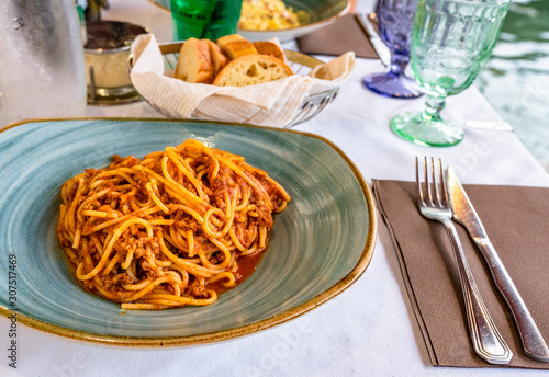 Pasta spaghetti bolognese in Venice, Italy at outside terrace restaurant on the grand canal. Tradidional italian food.