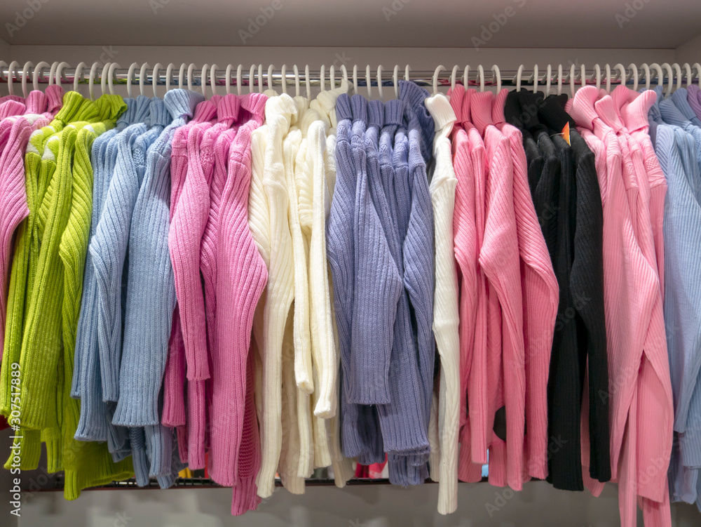 Colorful clothes, turtlenecks on hangers in the store. Shopping Mall, sale, shopping.