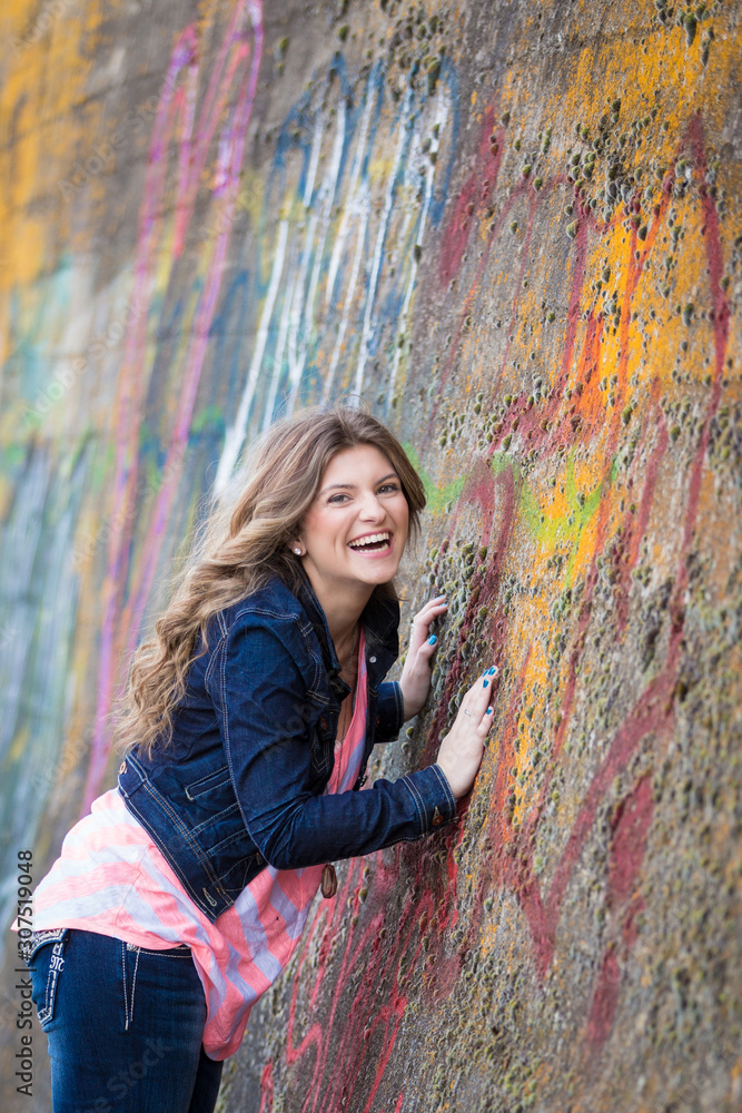 Laughing teen against graffiti wall
