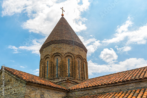 Conical dome of the Church of the virgin Mary against the blue sky in the fortress of Ananuri