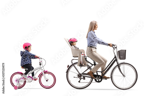 Mother riding a bicycle with a child and girl riding behind