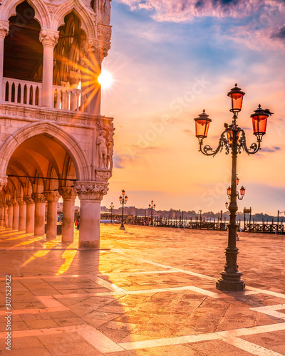 Doge's Palace at sunrise in Venice, Italy - Saint Mark square in an early morning with sun rays coming through the building at golden hour.