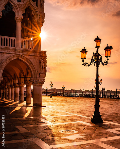 Doge's Palace at sunrise in Venice, Italy - Saint Mark square in an early morning with sun rays coming through the building at golden hour. © 365_visuals
