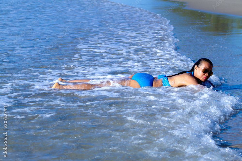 Woman and bikini blue happy relax with wave at the beach