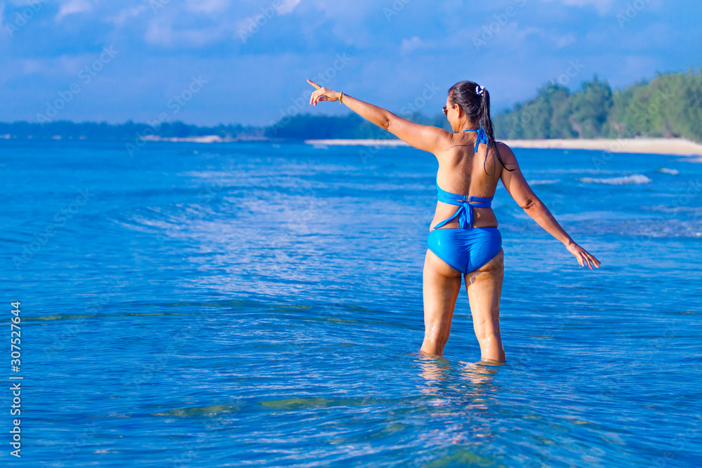 Woman and bikini blue sexy jump on wave at beach Woman and bikini blue sexy jump on wave at beach
