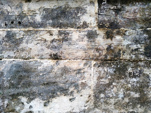 Abstract texture of mossy, porous, cracked and weathered sandstone walls. Wall texture can be used as a wall frame and wall background. Dirty and Old sandstone wall texture background.
