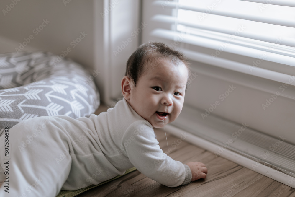 Asian baby boy lying beside window during tummy time at home Asian baby boy lying beside window during tummy time at home