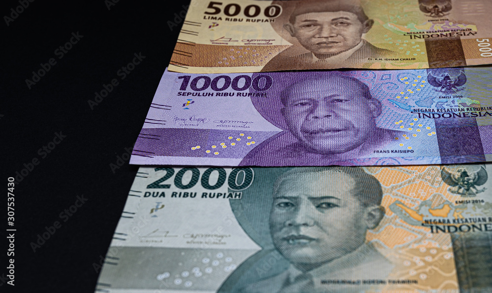 Indonesian rupiah money notes isolated on black background. Studio shot of Indonesia IDR currency.