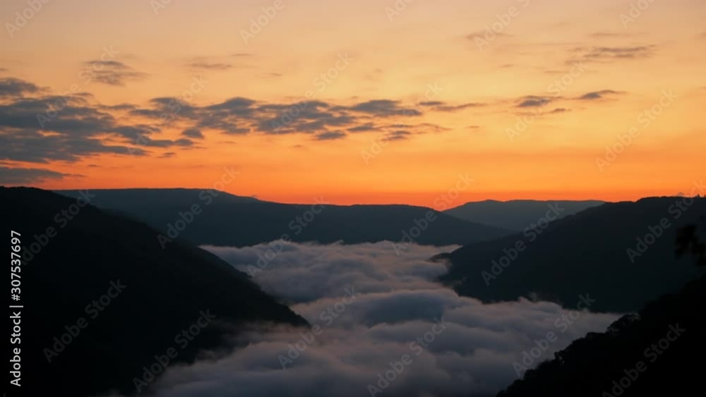 Mountains fog mist clouds in morning floating above new river gorge valley in Grandview Overlook, West Virginia during morning colorful sunrise zooming in Mountains fog mist clouds in morning floating above new river gorge valley in Grandview Overlook, West Virginia during morning colorful sunrise zooming in
