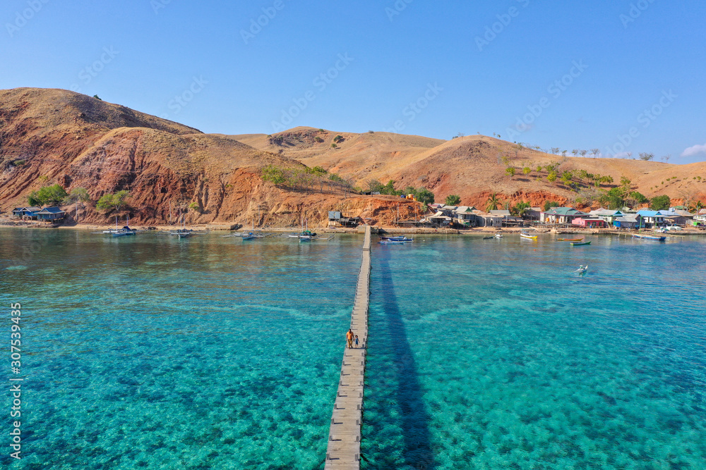 Aerial and top view the beautiful blue ocean and fisherman village at the remote island called Papagarang located in Komodo National Park, Indonesia.