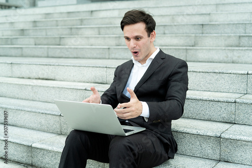 Medium Shots Asian man suprising when look market stocks sitting at outdoor stairs photo