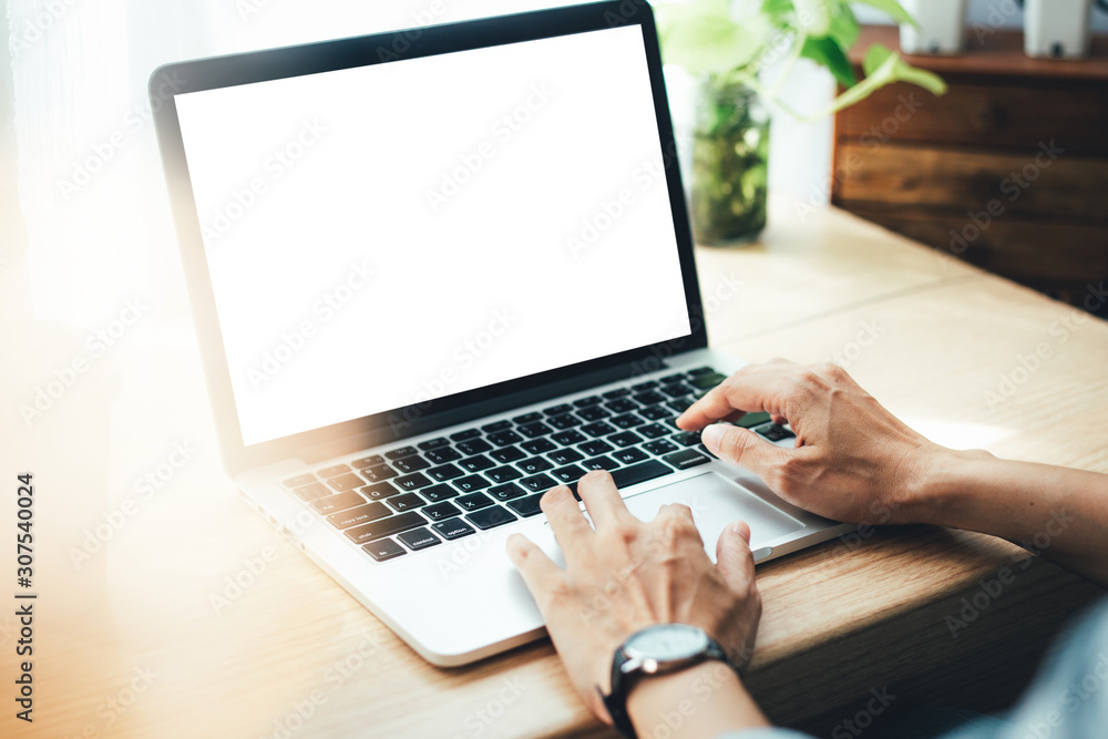 mockup image blank screen computer with blank white background for advertising text,hand man using laptop contact business search information on desk at home office.marketing and creative design mockup image blank screen computer with blank white background for advertising text,hand man using laptop contact business search information on desk at home office.marketing and creative design