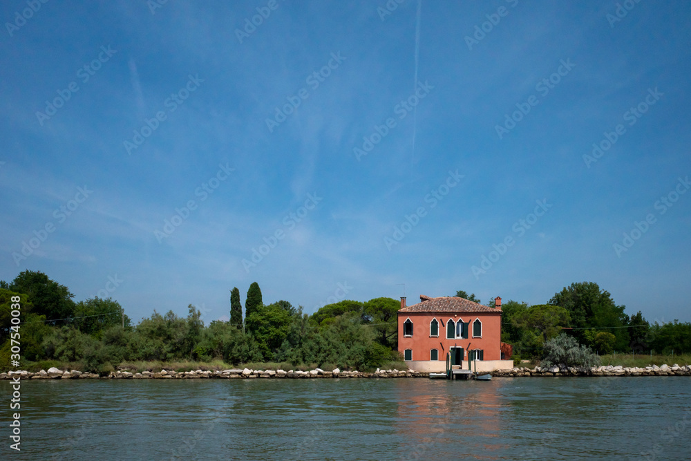 Obraz premium Red house by water, island of Mazzorbo, near Burano, Venice, Italy