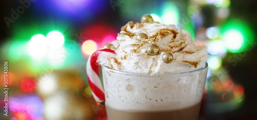 Original coffee with whipped cream is decorated with food confectionery gold balls and food glitters. original decoration idea with food gold. festive mood.
