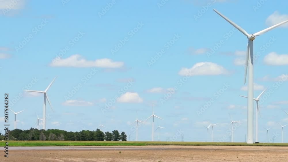 Wind turbines rural farm near Roscoe Texas or Snyder in USA in prairie with rows of many machines for energy panning driving pov in slow motion Wind turbines rural farm near Roscoe Texas or Snyder in USA in prairie with rows of many machines for energy panning driving pov in slow motion