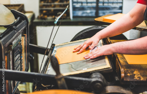 Fotografía A university student uses an old printing press in a college printmaking class