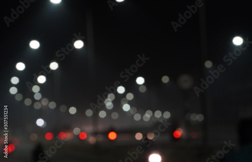 Abstract blurred image of road at night time with vehicle light bokeh for background usage, City road vehicles and heavy traffic moving at speed. 