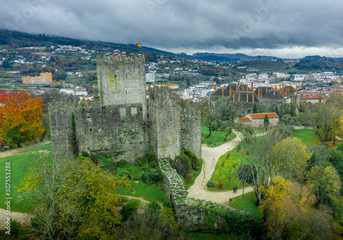 Aerial view of well-preserved medieval buildings hilltop, 10th-century Guimarães Castle with its sweeping city views. Restored Dukes of Bragança Palace, Romanesque São Miguel do Castelo Church