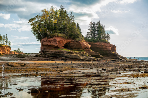 Tourists dwarfed by Natural formations at Burntcoat Head, the site of the highest recorded tides in the world located in Nova Scotia, Canada during low tide photo