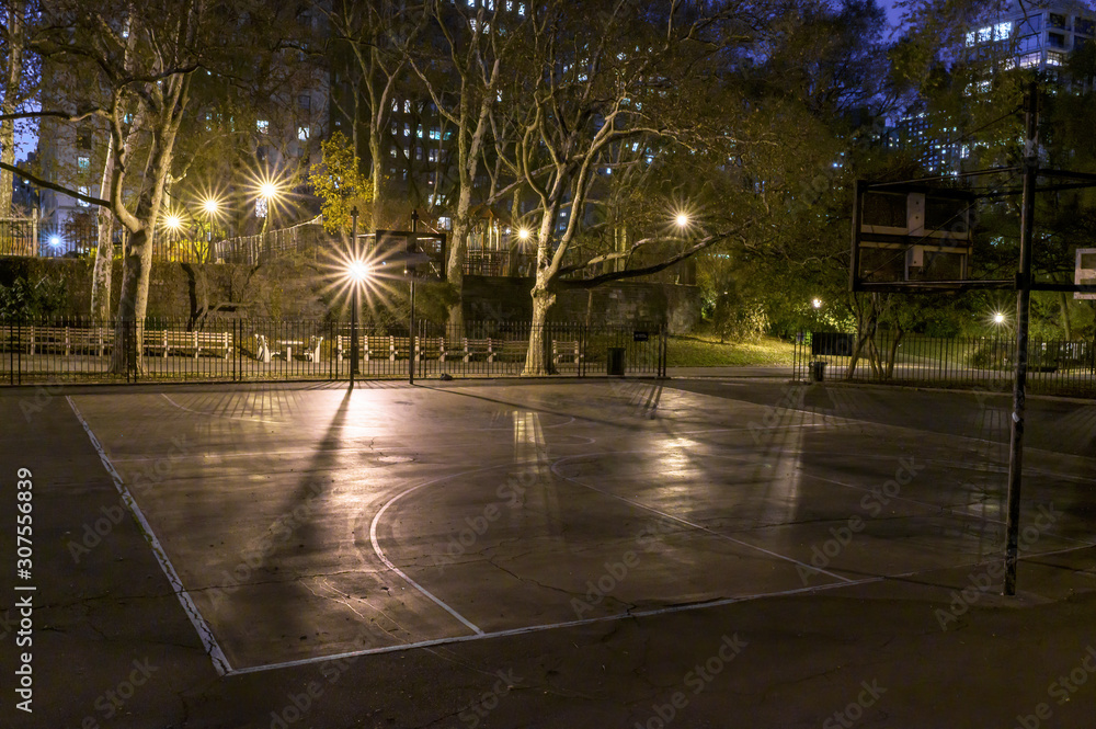 Night time shot of an empty basketball court in a public park in Manhattan, New York City